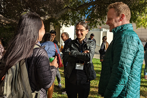 Resources and Support: Faculty and postdocs talking on the Barker lawn